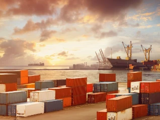 Shipping containers stacked up with sea in the background