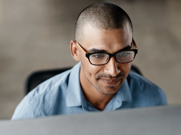 ethnic IT man studying his computer screen