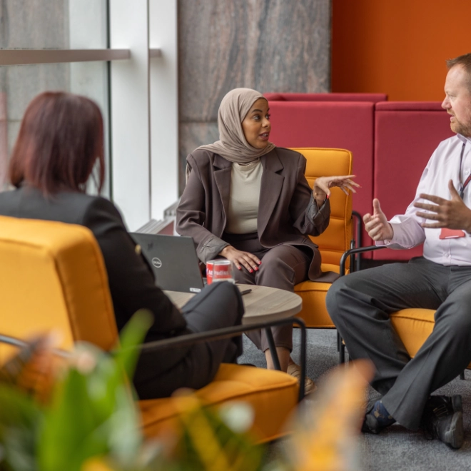Two women and man on orange seats meeting 4